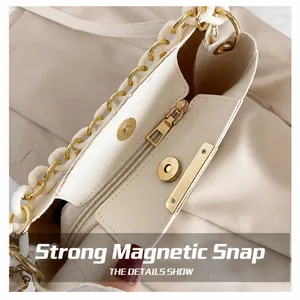Internal detail of beige bucket bag showing magnetic snap closure and zipper pocket