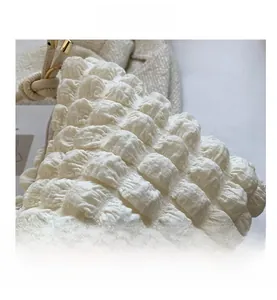 Gros plan sur la texture bouffante blanche et les détails de nœuds du sac matelassé