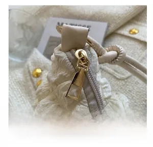 Détail du sac blanc à texture bulle avec fermeture éclair dorée et bandoulière cuir