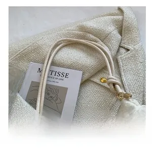 Détail du tissu matelassé nuage et des fines lanières nouées sur le sac à bandoulière beige