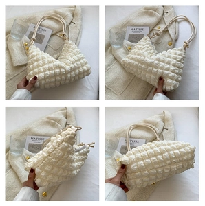 Détail du sac à bandoulière crème avec texture à bulles et fermeture éclair moderne