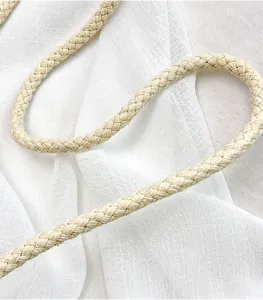 Detail van de gladde geweven schouderband in gebroken wit voor een zomerse tas