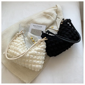 Détail de la texture gaufrée des sacs à bandoulière croissants noir et blanc