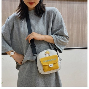 Detalle del bolso bandolera de lona Harajuku con bordado y textura de la tela