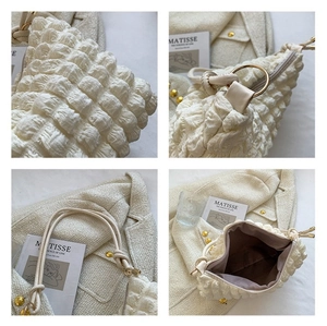 Détails de la texture bulle du sac blanc avec anneaux dorés et bandoulière cordon