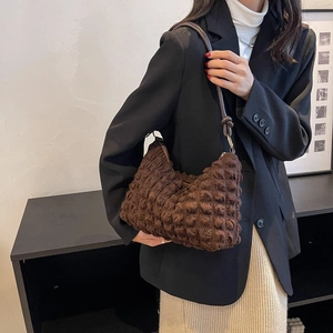 Gros plan d'un sac à bandoulière marron foncé en tissu plissé avec détails en anneau métal