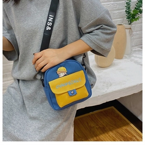 Primer plano del pequeño bolso bandolera de lona azul y amarillo con dibujo animado