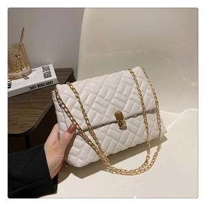 Detailed close-up of white quilted PU leather chain bag with golden swivel lock and strap