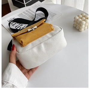 Detalle de bolso bandolera de lona amarillo y blanco con bordado CHAOMETA