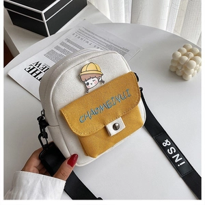 Detalle del mini bolso bandolera de lona con parche de niña y bolsillo amarillo