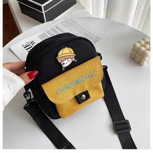 Detalle de mini bolso bandolera de lona con bordado de niña y correa ajustable