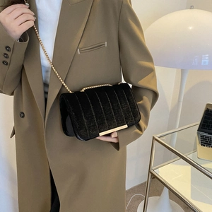 Minimalistische schwarze Samt-Umhängetasche mit vertikaler Prägung und Goldkette