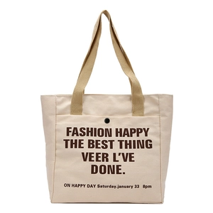 Minimalist beige canvas tote bag with front pocket and decorative typography for women