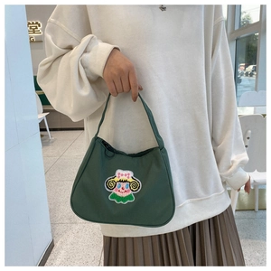 Detail of vintage green nylon handbag featuring a cute cartoon girl embroidery patch