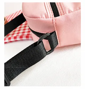 Detalle de tela de nailon rosa con costuras prolijas y hebilla en D de metal negro mate