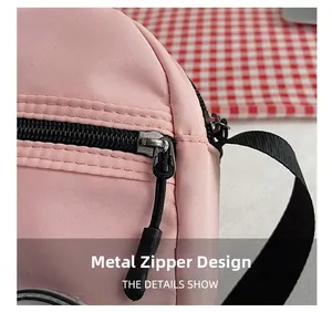 Detalle de cremallera metálica negra y correa de nailon en bolso de lona rosa