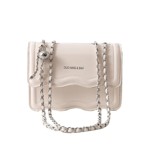 Minimalist beige crossbody bag with wavy flap design and silver metal ball chain strap