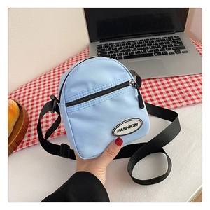 Mini bolso bandolera de nailon azul claro para mujer con etiqueta de moda y correa negra
