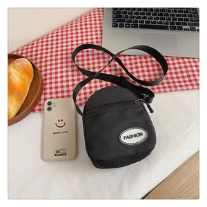 Detalle de un bolso bandolera negro de lona con logo Fashion en una escena de estilo