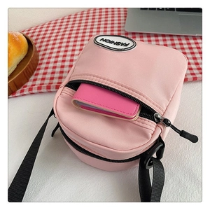 Detalle del mini bolso bandolera de nailon rosa con bolsillo frontal y tarjetero