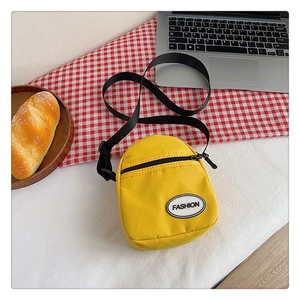 Bolso bandolera minimalista de lona amarilla con etiqueta fashion y correa