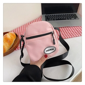 Bolso bandolera de lona rosa con bolsillo frontal y correa ajustable de color negro