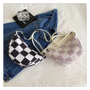 Flat lay of checkered knit crossbody bags in black and lavender with wide straps