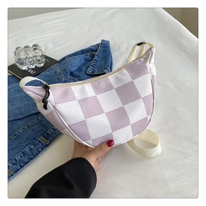 Detail of purple checkered crescent bag with knit texture and white adjustable strap