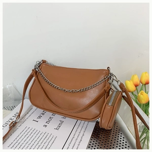 Detail of caramel crescent shoulder bag with silver chain and mini round coin purse