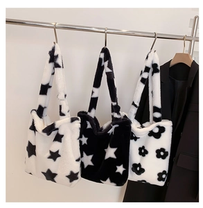 Detail view of plush flower and star pattern tote bags hanging next to a blazer