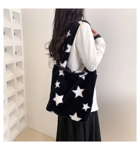 Detail of soft black and white plush tote bag featuring a large white star pattern design