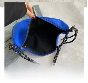 Détail de l'intérieur spacieux du sac bandoulière en nylon bleu avec sangle corde