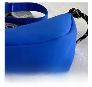 Gros plan d'un sac demi-lune bleu roi avec des sangles tissées et des cordons de serrage