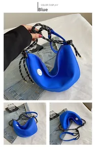 Détail du sac bandoulière bleu en forme de croissant avec motif smiley et corde