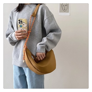Détail d'un sac bandoulière jaune en demi-lune avec bandoulière en corde tressée