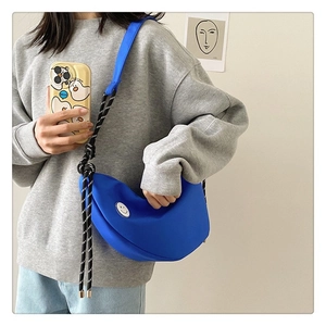 Détail du sac bandoulière croissant bleu avec bandoulière en corde et logo smiley