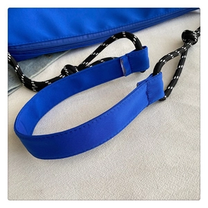 Détail du sac en toile bleue avec bandoulière en corde tressée noire et blanche et rembourrage