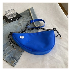 Sac bandoulière bleu en toile avec sangle tissée et détail de patch visage souriant