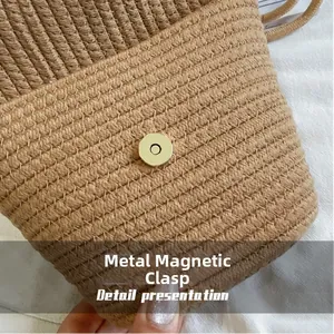 Detailed close-up of the gold magnetic metal buckle on a woven cotton bucket bag