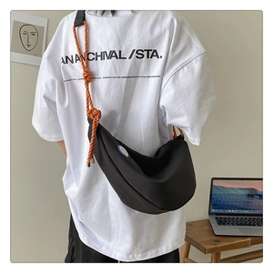 Sac bandoulière demi-lune en toile noire avec sangle corde orange sur mannequin
