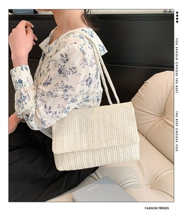 Detail of cream-white woven tote bag featuring herringbone pattern and rope shoulder strap