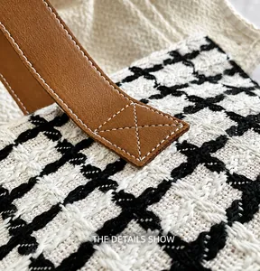 Detail showing reinforced brown leather handle and black-and-white checkered woven fabric