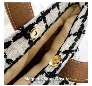 Macro shot of strong gold magnetic closure and tweed fabric texture on a handheld bag