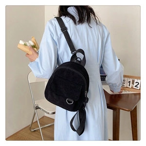 Détail d'un mini sac à dos en velours côtelé noir avec bretelles réglables et poche