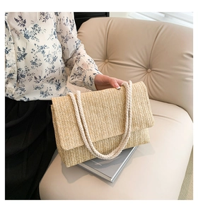 Detail einer Strohtasche mit dickem Seilschultergurt im lässigen Urlaubs-Stil