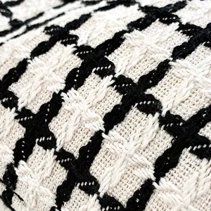 Macro shot of high-quality black and white checkered tweed fabric showing weave detail