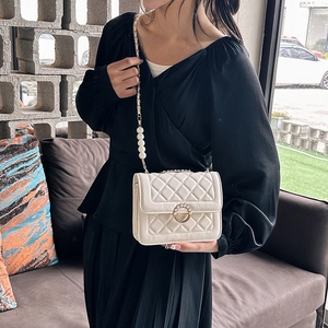 Elegant white quilted crossbody bag with pearl handle chain and gold circular buckle