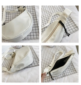 Detalle del bolso de media luna de nailon blanco mostrando el forro y la correa ajustable