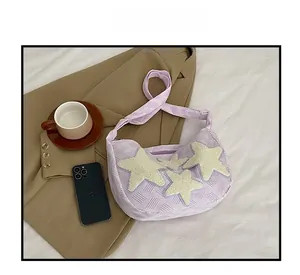 Détail du sac à main violet en nylon avec des patchs d'étoiles en peluche crème