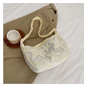Détail du sac en toile crème avec patchs étoiles blanches et texture de tissu tissé
